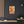 Canvas wall art with a bold orange and yellow Illustration of Greek historian Herodotus on a dark wall above a shelf