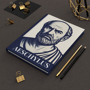 Hardcover notebook with Aeschylus illustration on a dark surface with stationery items.