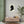 Fine art poster with a black on ivory silhouette illustration of musician Johann Sebastian Bach on a wall above a wooden cabinet with decorative items.