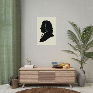 Fine art poster with a black on ivory silhouette illustration of musician Johann Sebastian Bach on a wall above a wooden cabinet with decorative items.