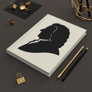 Hardcover journal with a black on ivory silhouette illustration of musician Johann Sebastian Bach on a dark surface with office supplies