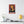 Canvas wall art with a bold illustration of philosopher Francis Bacon on a wall above a shelf with decor items.