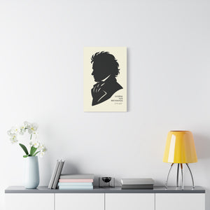 Canvas wall art with a black on ivory silhouette illustration of musician Ludwig van Beethoven on a wall above a table with decor items.