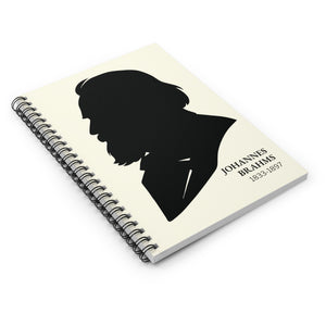 Spiral notebook with a black on ivory silhouette illustration of musician Johannes Brahms flat on a white surface