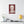 Canvas wall art with a bold illustration of Roman emperor Caligula on a wall above a table with a lamp and books.