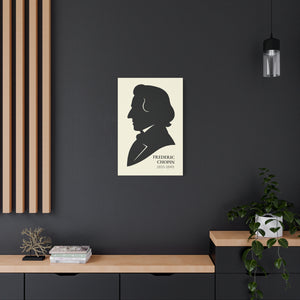 Canvas wall art with a black on ivory silhouette illustration of musician Frederic Chopin on a dark wall with a wooden shelf and plant.