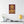 Canvas wall art with a bold illustration of Roman emperor Commodus on a wall above a table with decor items.