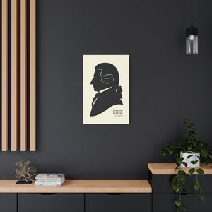 Canvas wall art with a black on ivory silhouette illustration of musician Joseph Haydn on a dark wall with a wooden shelf and plant in the foreground