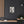 Canvas wall art with a bold illustration of Roman general and consul Julius Caesar on a dark wall with wooden shelves and decor.