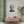 Fine art poster with a bold illustration of Roman general and consul Julius Caesar on the wall above a wooden cabinet.