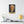 Canvas wall art with a bold illustration of philosopher John Locke on a wall above a table with books and a lamp.