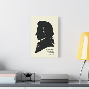 Canvas wall art with a black on ivory silhouette illustration of musician Wolfgang Amadeus Mozart on a wall above a desk.