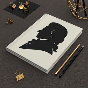 Hardcover journal with a black on ivory silhouette illustration of musician Wolfgang Amadeus Mozarton a dark surface.