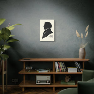 Canvas wall art with a black-on-ivory silhouette illustration of musician composer Franz Schubert above a wooden shelf with books and decor.