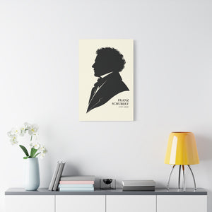 Canvas wall art with a black-on-ivory silhouette illustration of musician composer Franz Schubert on a wall above a shelf with decor items.