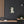 Canvas wall art with a bold illustration of Roman prefect Sejanus on a dark wall with wooden shelves and decor.