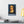 Canvas wall art with a bold illustration of philosopher Baruch Spinoza on a wall above a desk with books and a lamp