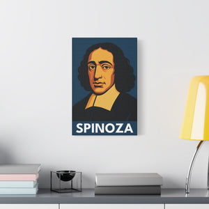 Canvas wall art with a bold illustration of philosopher Baruch Spinoza on a wall above a desk with books and a lamp