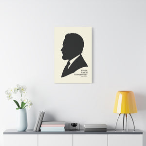 Canvas wall art with a black on ivory silhouette illustration of musician Pyotr Ilyich Tchaikovsky on a wall above a shelf with decor items.