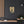 Canvas wall art with a bold black and beige illustration of ancient Greek historian Thucydides on a dark wall above a shelf