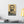 Canvas wall art with a bold black and beige illustration of ancient Greek historian Thucydides on a white wall above a desk