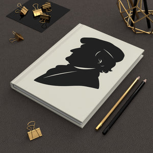 Hardcover journal with a black on ivory silhouette illustration of musician Richard Wagner on a dark surface with office supplies.
